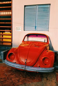 Red vintage car against building in city