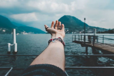 Low section of woman legs against railing against sky