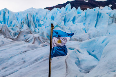 Close-up of flag on snow covered mountain