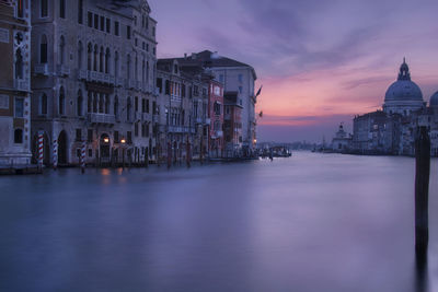 Reflection of buildings in city at sunset