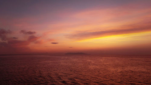 Scenic view of sea against dramatic sky during sunset