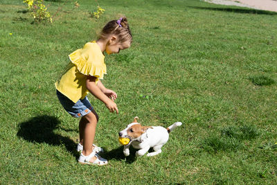 Side view of boy playing with ball on field