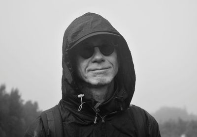 Portrait of man in hood against sky 