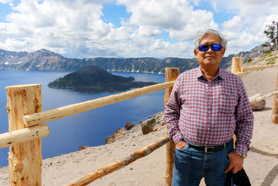 Young man wearing sunglasses standing on mountain