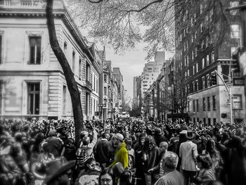 Crowd on city street by buildings