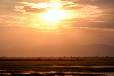 Scenic view of field against sky during sunset