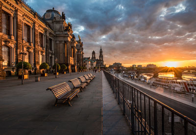 Empty benches by dresden frauenkirche in city during sunset