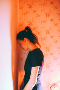 Young woman standing in corner