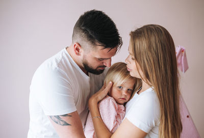 Happy multinational family with baby girl little daughter having fun in children room at home