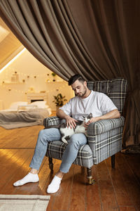 Man with cat sitting on chair