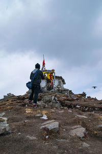 Men standing on rock against sky