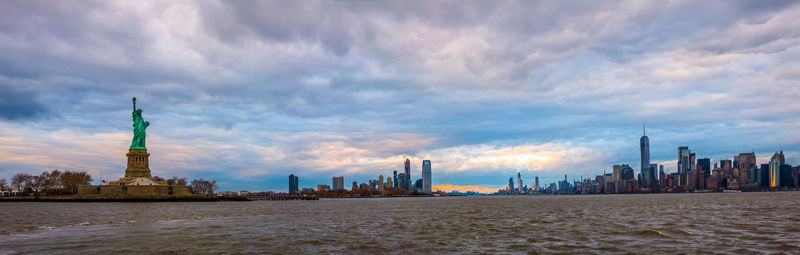 Manhattan skyline sunset panorama and cityscape from hudson and view of buildings against cloudy sky