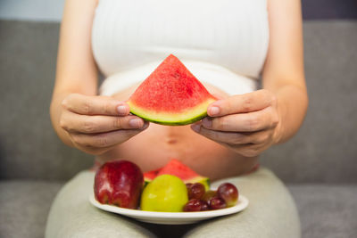 Midsection of woman holding fruits
