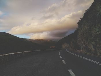 Road amidst mountains against sky