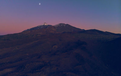 Scenic view of mountains against clear sky at dusk