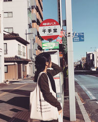 Full length of woman standing on street in city