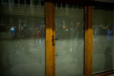 Reflection of man on illuminated mirror