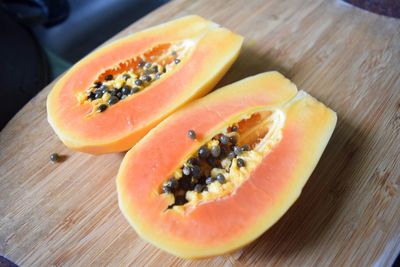 Close-up of halved papayas on cutting board