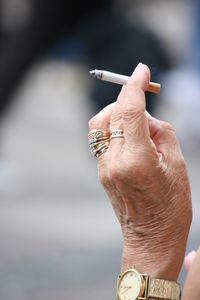 Senior person holding cigarette in hand