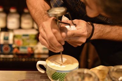 Man making latte at coffee shop