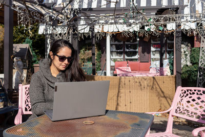 Woman using laptop on table at cafe