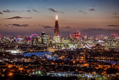 Aerial view illuminated buildings in city at dusk