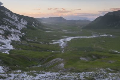 Scenic view of river and mountains against sky