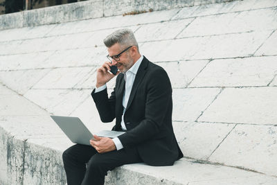 Full length of man using mobile phone