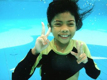 Portrait of smiling young woman swimming in pool