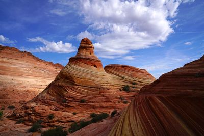 Rock formations on landscape against cloudy sky