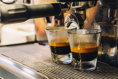 Espresso in glass below coffee maker at cafe