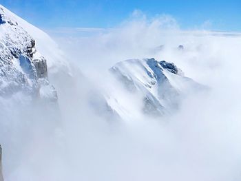 Low angle view of snowcapped mountains against sky