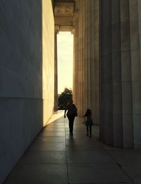 Two people walking in corridor