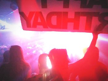 Low angle view of people against illuminated building