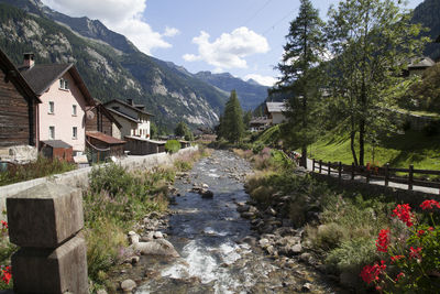 Footpath amidst houses and buildings against sky