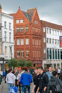 People on street against buildings in city