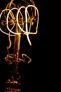 Close-up of illuminated light painting against black background