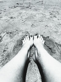 Low section of woman standing on sand