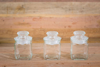 Close-up of glass jar on table against wall
