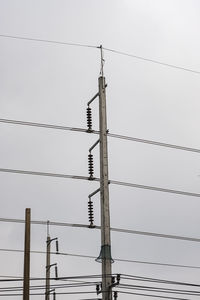 Low angle view of electricity pylon against clear sky
