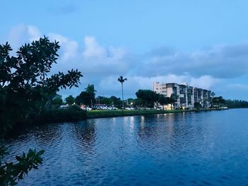 Scenic view of lake by buildings against sky