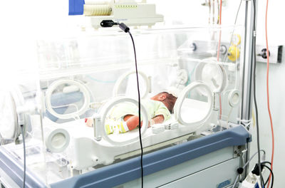 Newborn baby in incubator at hospital