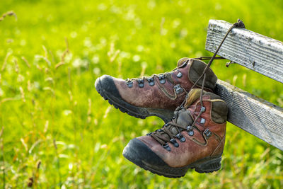 Close-up of boot hanging on wood at farm