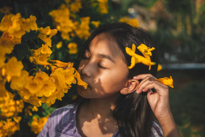 Close-up of woman with yellow flower