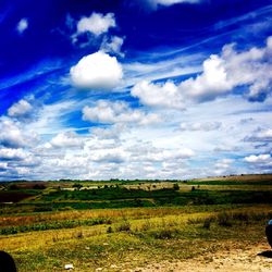 Scenic view of field against cloudy sky