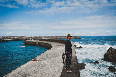 Woman standing on beach against sky