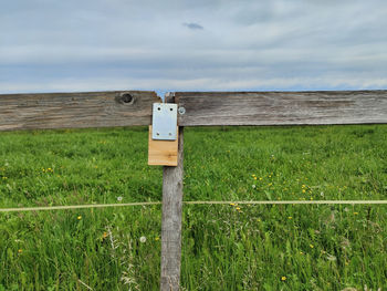 Wooden fence on field against sky