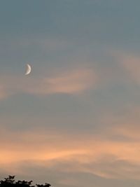 Low angle view of silhouette moon against sky at sunset
