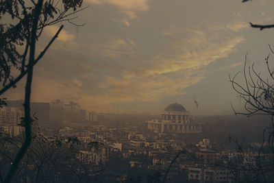 Buildings in city against sky at sunset