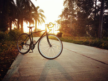 Bicycle parked by road against sky